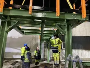 Unser Team im Einsatz bei Großprojekt im Anlagen- und Kraftwerksservice Gruppenfoto eines Montageteams in Warnwesten vor einer Industrieanlage.